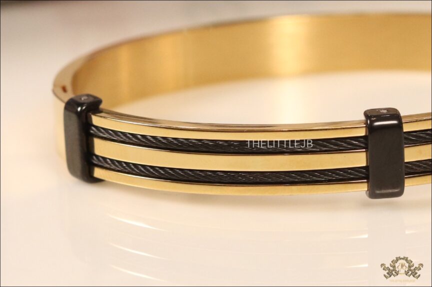 Flat golden bracelet with black rope and metal effect -