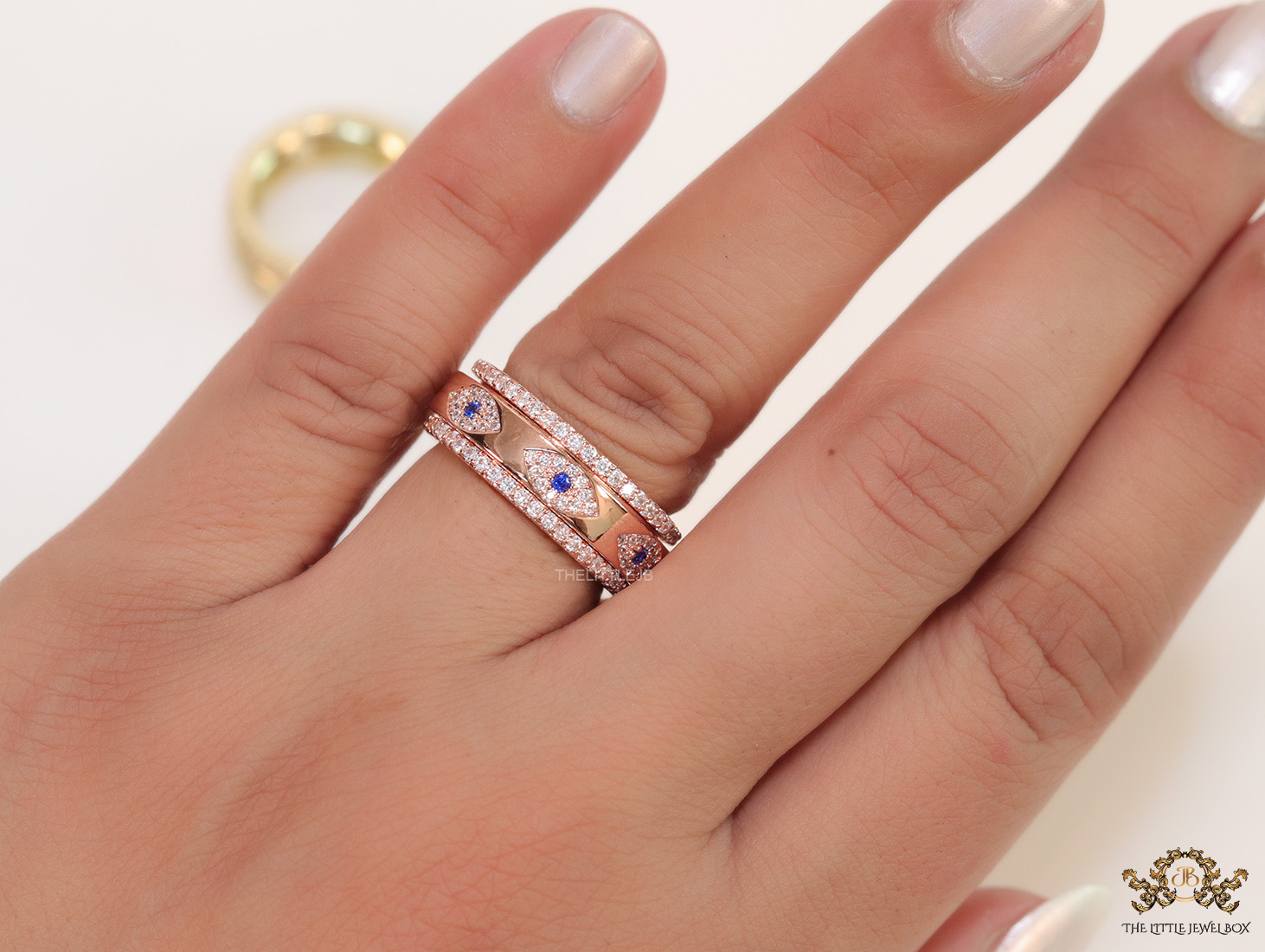 8mm Rotating centre Rose Gold plated band with multiple cz evil eyes