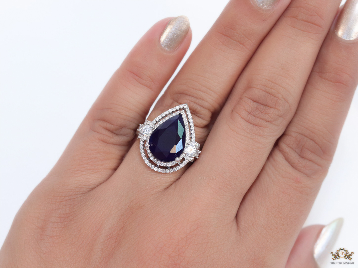 Platinum plated cz open ring with sapphire blue drop stone