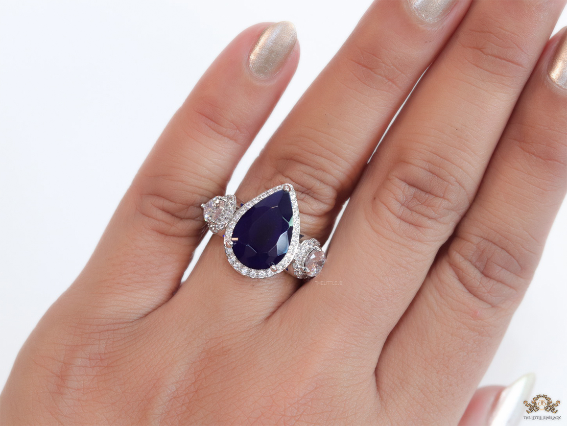 Drop shaped sapphire blue stone open ring with cz