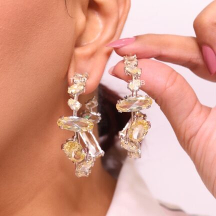 Asymmetrical yellow stones on platinum hoops